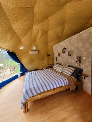 a bedroom with a bed with a yellow ceiling at Nomad Glamping in Šipovo