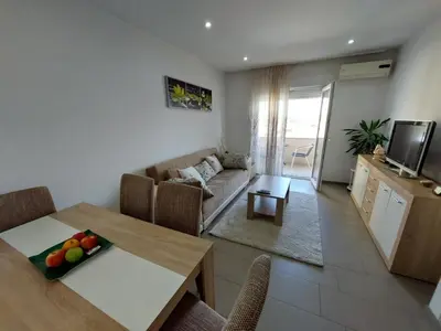 a kitchen and a living room with a table and a couch at HELA Lux apartment in Modriča