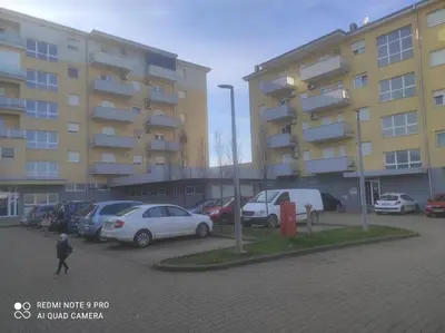 a parking lot with cars parked in front of a building at HELA Lux apartment in Modriča