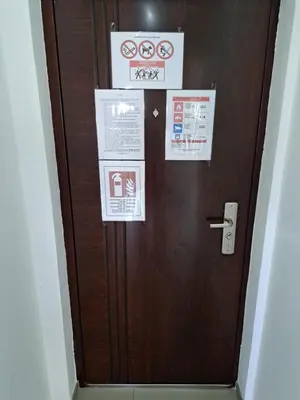 a brown door with signs on it in a room at HELA Lux apartment in Modriča
