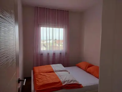 a small bedroom with a bed and a window at HELA Lux apartment in Modriča