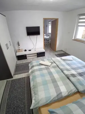 a bedroom with two beds and a flat screen tv at AURORA in Visoko