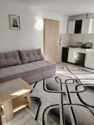 a living room with a couch and a kitchen at AURORA in Visoko