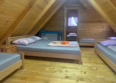 a bedroom with two beds in a log cabin at Kuća za odmor Unski Raj in Rudice