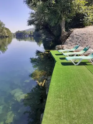 a row of lawn chairs sitting next to a river at Kuća za odmor Unski Raj in Rudice