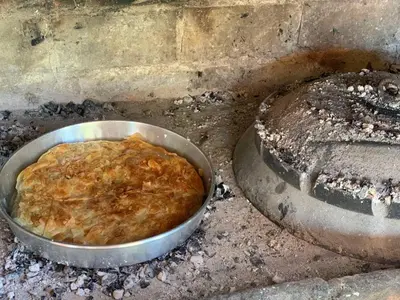 a metal pan of food in a bowl on the ground at Kuća za odmor Unski Raj in Rudice