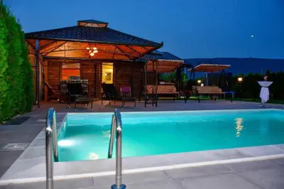 a swimming pool in front of a house with a pavilion at River Homes Bihac in Bihać