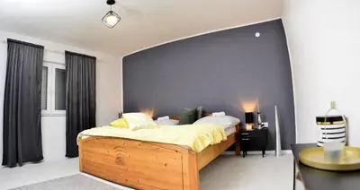 a bedroom with a large wooden bed with yellow sheets at Stela1 in Drvar