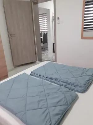 a bed with a blue cover on top of it at Apartman Cirkic in Sanski most