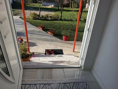 an open door with a view of a sidewalk at Apartman Cirkic in Sanski most