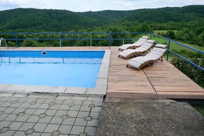 a group of lounge chairs sitting next to a swimming pool at Bosnian Mountain Retreat in Prijedor