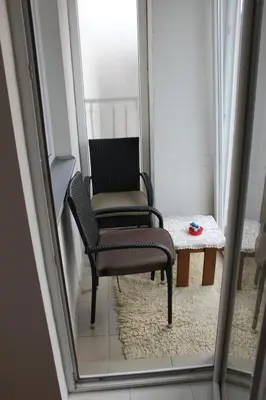 a mirror reflection of a chair and a table at Apartman Romana in Doboj