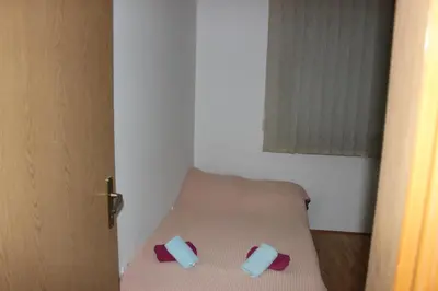 a small room with a bed with two pillows on it at Apartman Romana in Doboj