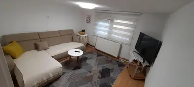 a living room with a couch and a television at Sunset Apartment in Visoko