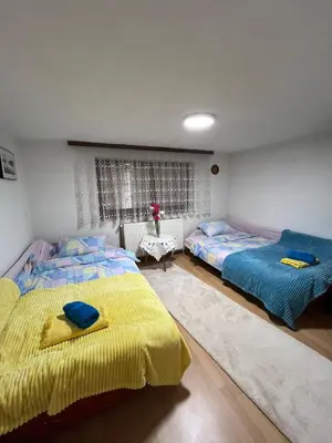 a bedroom with two beds and a table in it at Sunset Apartment in Visoko
