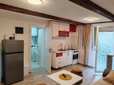 a kitchen with a refrigerator and a table in a room at S-E-N in Bosanski Novi