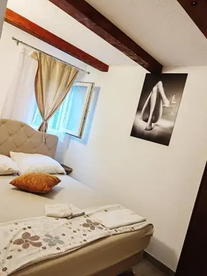 a bedroom with a bed and a picture on the wall at S-E-N in Bosanski Novi