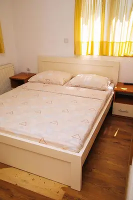a large white bed in a room with a window at Jezero Laminci in Bosanska Gradiška