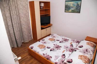 a small bedroom with a bed with flowers on it at Jezero Laminci in Bosanska Gradiška