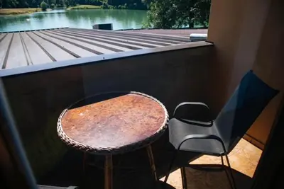 a table and a chair sitting next to a window at Jezero Laminci in Bosanska Gradiška