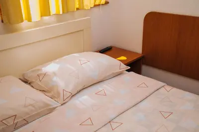 a bed with a pillow and a table in a room at Jezero Laminci in Bosanska Gradiška