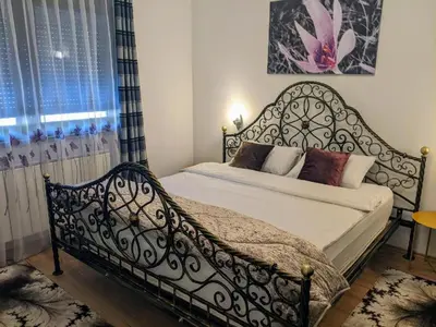 a bedroom with a bed with a wrought iron bed frame at Apartmani Hrastik 1 in Bihać