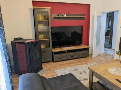 a living room with a television and a red wall at Apartmani Hrastik 1 in Bihać