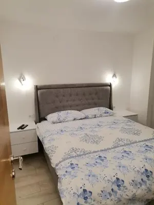 a bedroom with a bed with a blue and white comforter at City Break Apartment in Banja Luka