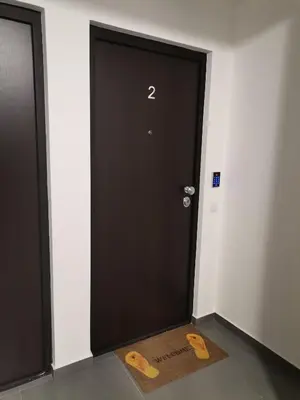 a black door with two wooden handles in a room at City Break Apartment in Banja Luka