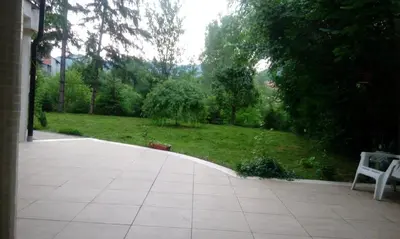 a patio with a white bench and a grass yard at Holiday Home Uma in Visoko