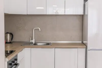 a kitchen with white cabinets and a sink at Drobac apartment in Banja Luka