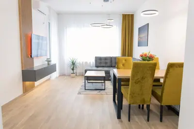 a dining room with a table and yellow chairs at Drobac apartment in Banja Luka