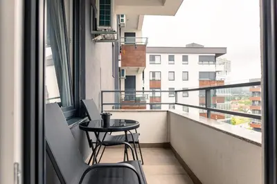 a balcony with a table and chairs and a view of a building at Drobac apartment in Banja Luka