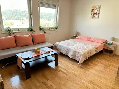 a bedroom with a bed and a couch and a table at Titanik Tuzla in Tuzla