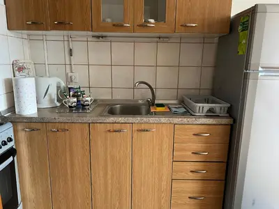 a kitchen with wooden cabinets and a sink at Titanik Tuzla in Tuzla