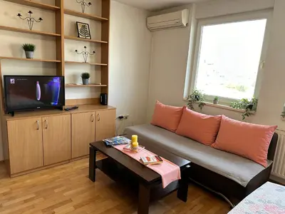 a living room with a couch and a tv at Titanik Tuzla in Tuzla
