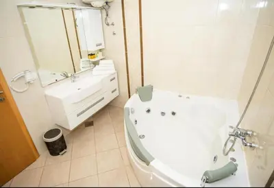 a white bathroom with a tub and a sink at Apartmani i sobe Centar Bugojno in Bugojno