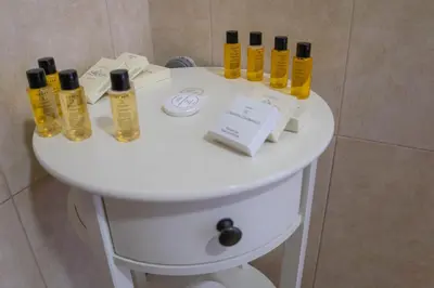 a white table with bottles of oils on it in a bathroom at Apartmani i sobe Centar Bugojno in Bugojno