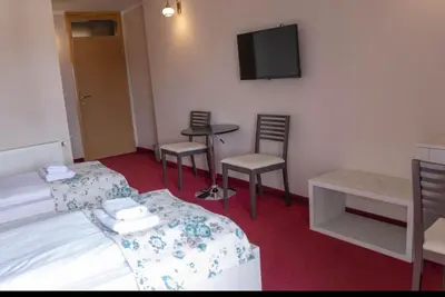 a room with chairs and a table and a tv at Apartmani i sobe Centar Bugojno in Bugojno