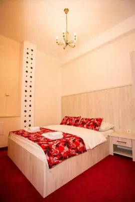 a bedroom with a large bed with a red blanket at Apartmani i sobe Centar Bugojno in Bugojno