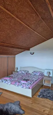 a bedroom with a large bed with purple sheets at Dream weekend house in Visoko