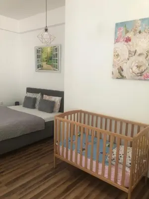 a bedroom with a crib and a painting on the wall at Gracia in Jajce