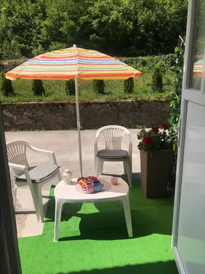 a patio with two chairs and an umbrella and a table at Gracia in Jajce