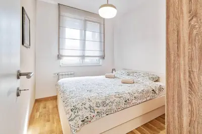 a small bedroom with a bed and a window at GOLDENBOY apartments, Banja Luka in Banja Luka