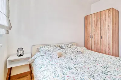 a bedroom with a bed and a wooden cabinet at GOLDENBOY apartments, Banja Luka in Banja Luka