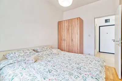 a bedroom with a bed and a wooden cabinet at GOLDENBOY apartments, Banja Luka in Banja Luka