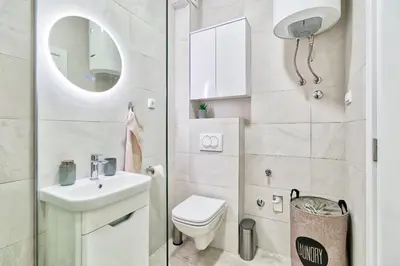 a bathroom with a toilet and a sink and a mirror at GOLDENBOY apartments, Banja Luka in Banja Luka