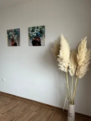 three pictures on a wall next to a vase with grass at Apartment Lux Lucis in Livno