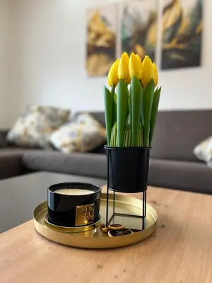 a vase of yellow tulips on a table at Apartment Lux Lucis in Livno