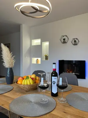a table with two glasses of wine and a basket of fruit at Apartment Lux Lucis in Livno